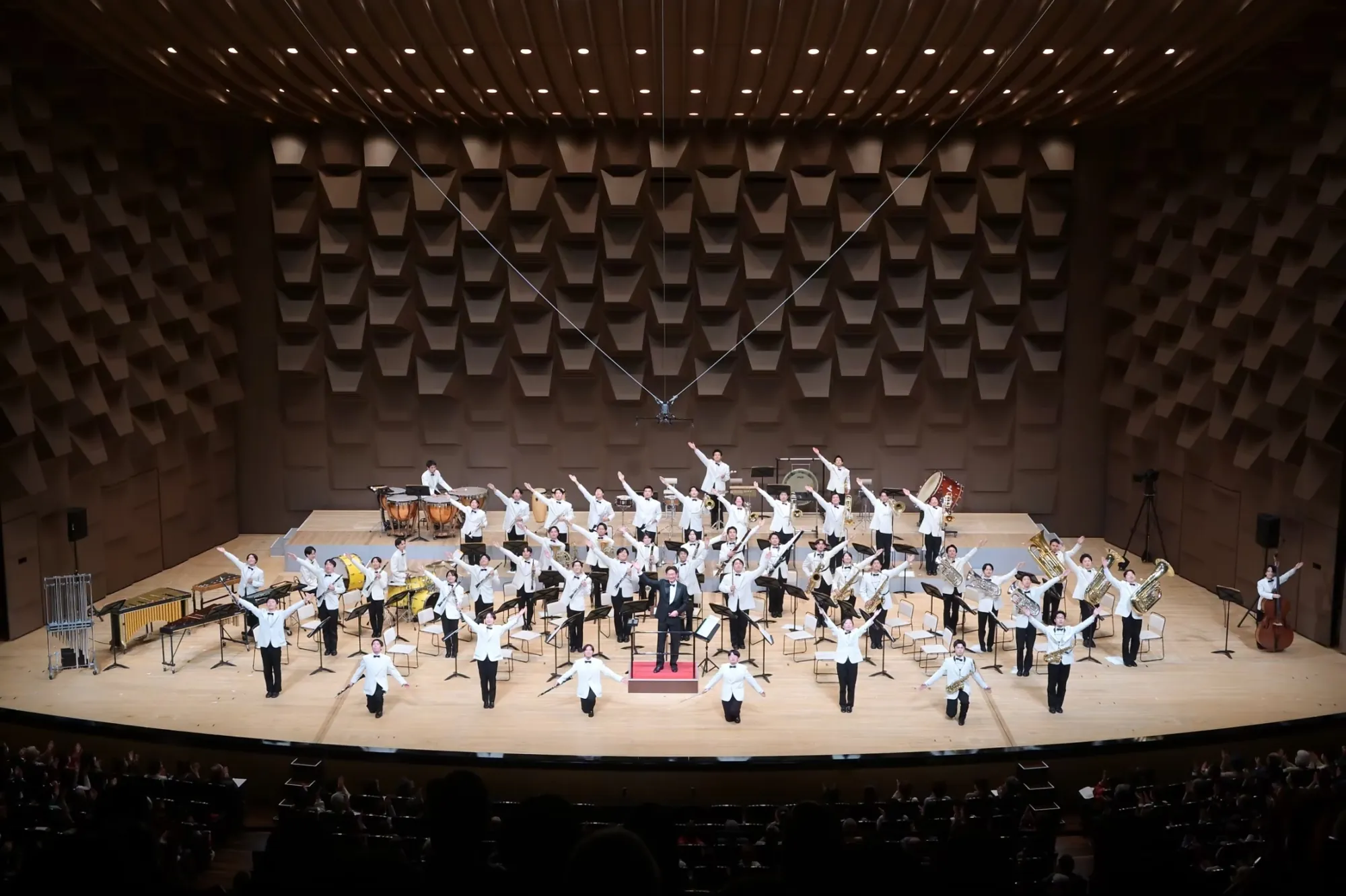 グリーンコンサートの舞台で、演奏を終えて両手を広げる淀工吹奏楽部の部員たち